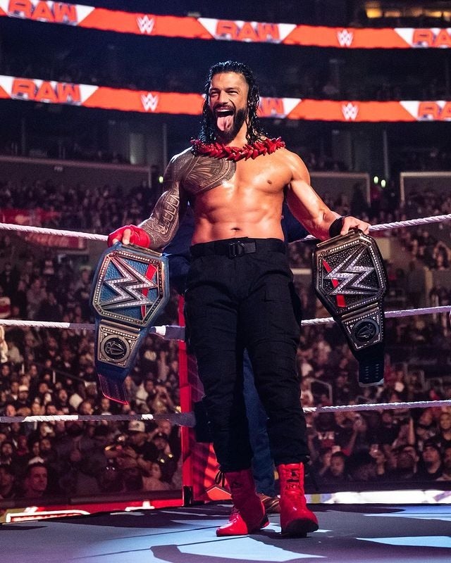 Roman con los campeonatos de la WWE