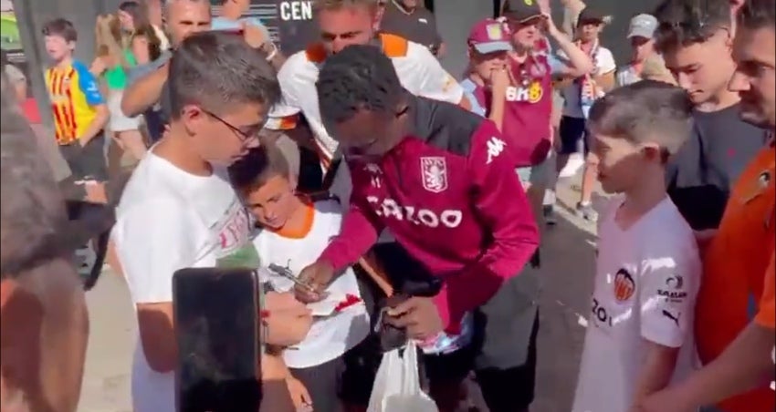 Aficionado de Aston Villa dando autógrafos como futbolista 