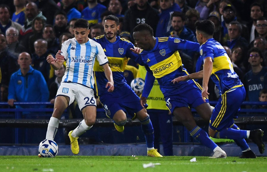 Agustín Ojeda con el balón ante jugadores de Boca