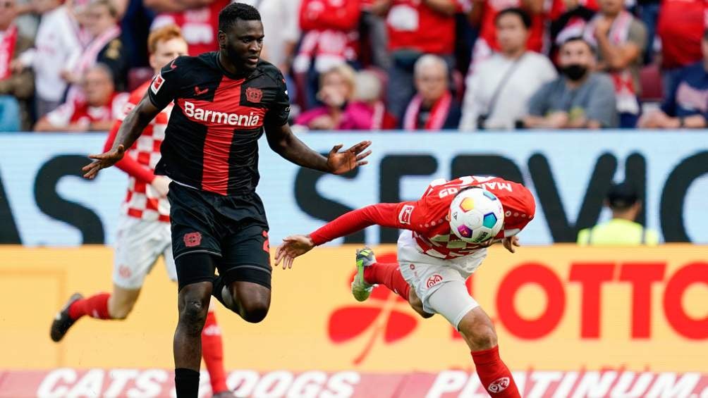 Victor Boniface del Leverkusen disputa un balón con Stefan Bell