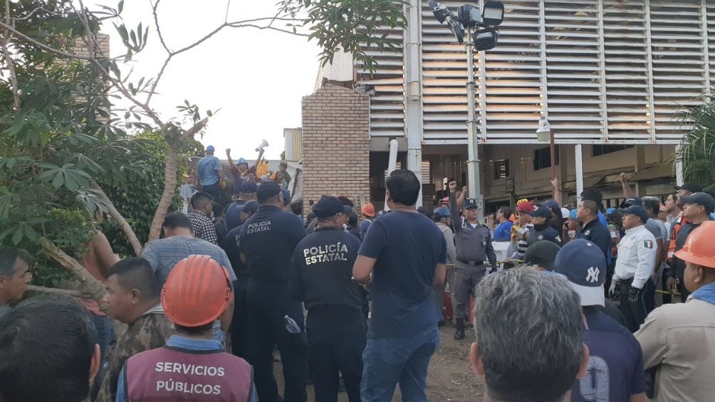 Miembros de la policía ayudando a remover escombros