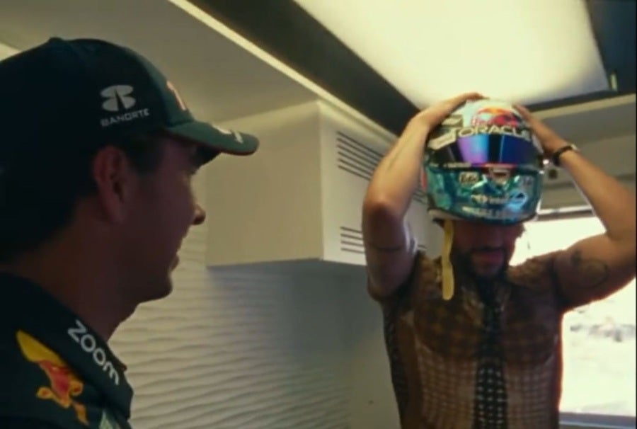 Bad Bunny tratando de ponerse el casco de Checo Pérez