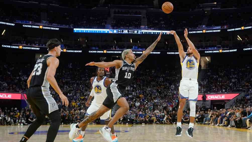 Jeremy Sochan intenta bloquear el tiro de Curry 