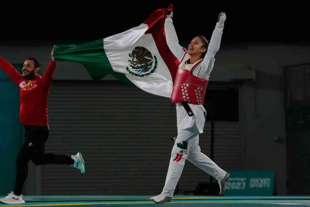 Leslie y su entrenador en festejo con la bandera de México