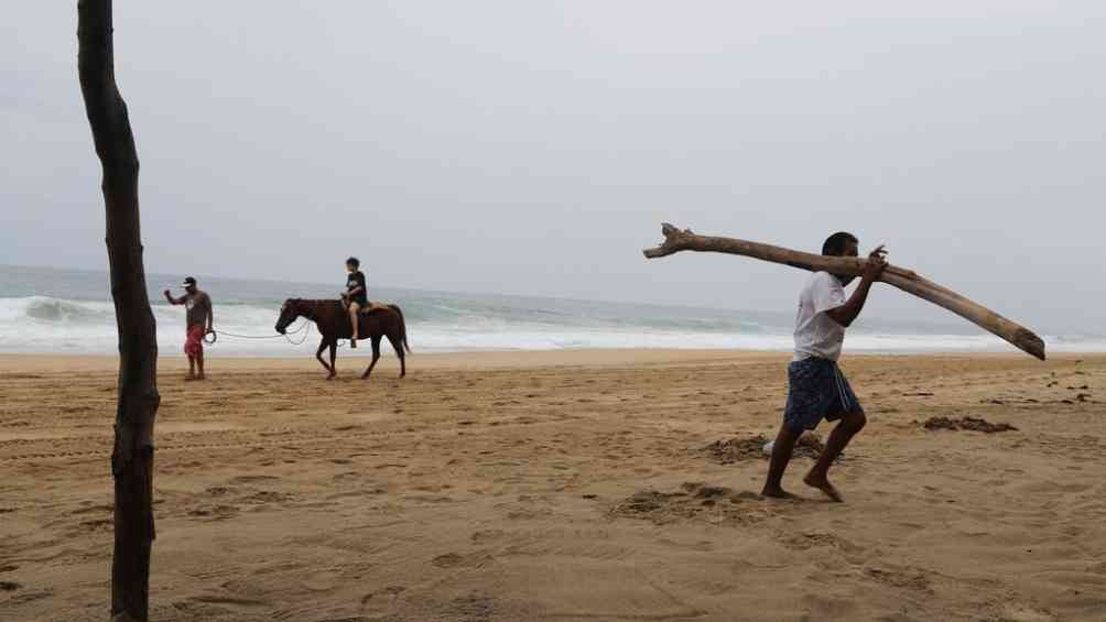 Turistas y habitantes en la playa de Acapulco durante el huracán