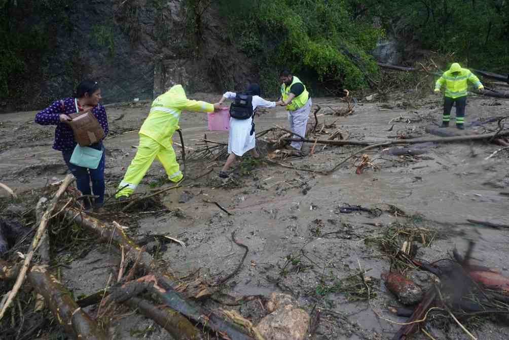 Personas intentan cruzar por la carretera afectada