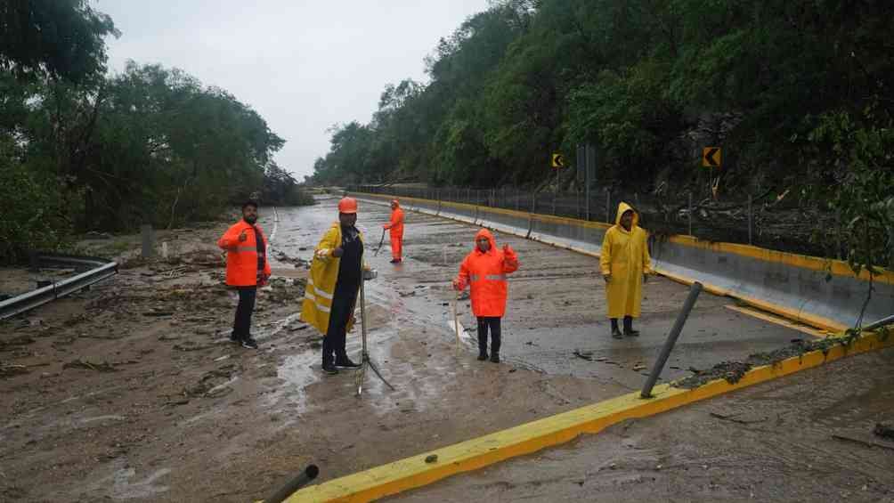 Trabajadores limpian la carretera tras el paso del huracán