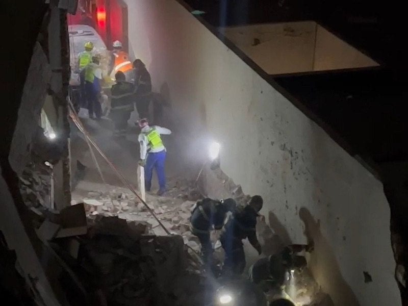 Los bomberos buscan a una persona entre los escombros.