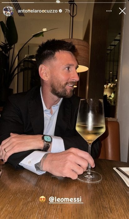 Messi con una copa de vino durante la cena