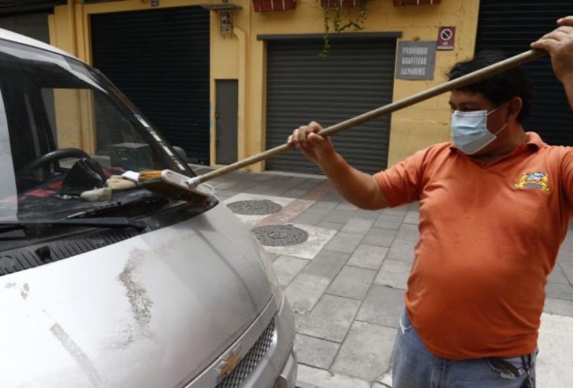 Las personas echan mano de cualquier herramienta para limpiar su auto de la ceniza. 