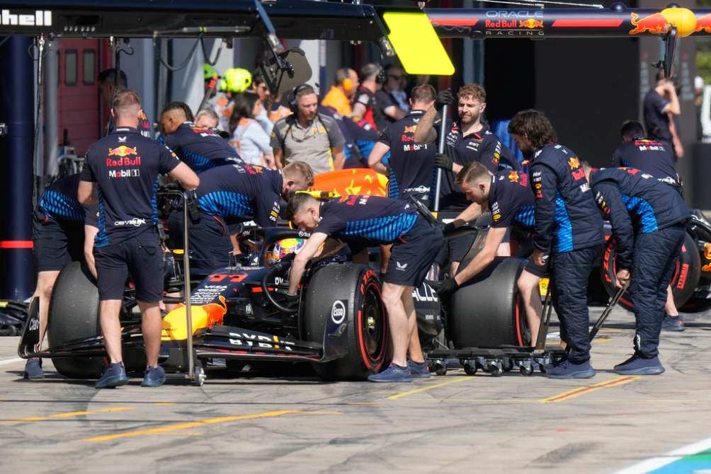 Mecánicos de Red Bull trabajan en el auto de Checo