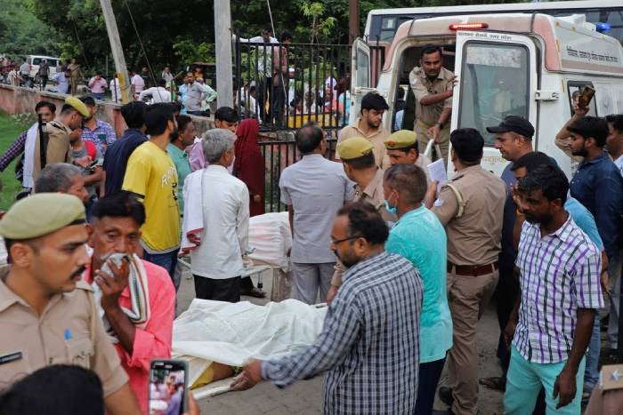 Familiares y voluntarios llevan los cuerpos en camillas en el hospital Sikandrarao en el distrito de Hathras