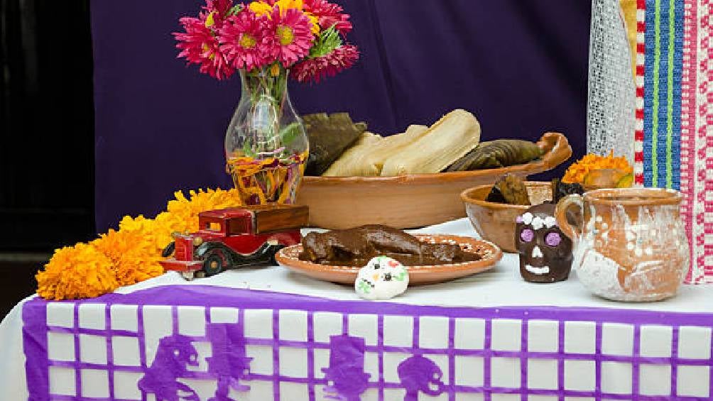 La ofrenda debe contener, fotografías, veladoras, papel picado de colores y comida. 