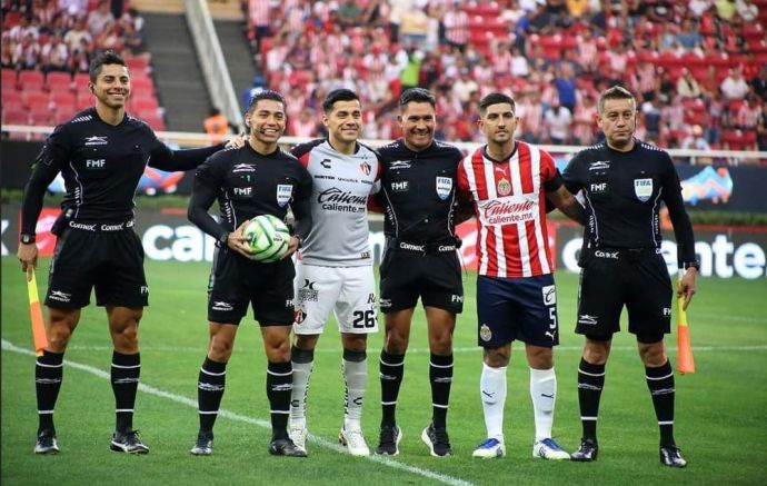 Imagen de los capitanes de Chivas y Atlas con el cuerpo arbitral