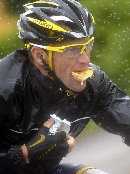 Lance Armstrong comiendo mientras compite bajo la lluvia durante la 13ª etapa del Tour de Francia el 17 de julio de 2009 | EFE