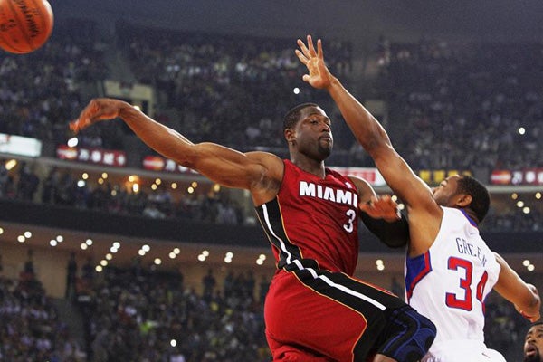 Dwyane Wade pelea por el control del balón con el jugador de Los Ángeles Clippers, Willie Green, en China| EFE