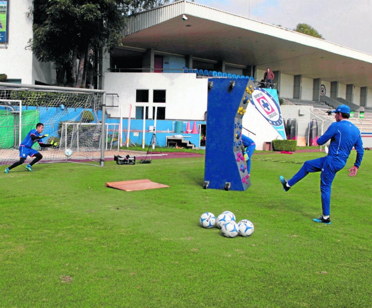 Entrenador lanza el balón a baja altura