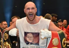 Tyson Fury festeja con los cinturones