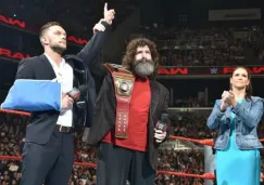 Finn Bálor (izq) entrega su título a Mick Foley (centro)