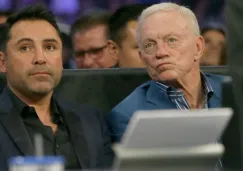 Oscar de la Hoya (izq) y Jerry Jones (der) observan la pelea de Canelo