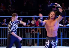 Johnny Impact festeja con el título en el centro del ring