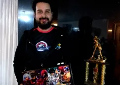 ViolentKain, posando con su joystick y el trofeo de campeón de KOF XIII que ganó en Costa Rica