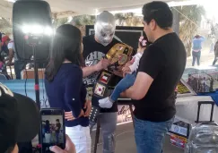 Imitador del Hijo del Santo firmando a fanáticos