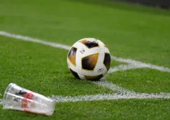 Balón y vasos en el césped del Estadio Jalisco