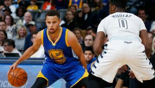 Curry intenta evadir la marca de un defensor