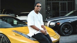 Ronaldinho posa con uno de sus autos