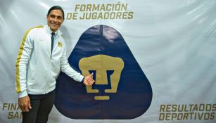 Paco Palencia posa para las cámaras junto al escudo de Pumas