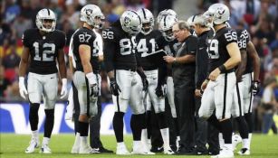 Jugadores de Raiders dialogan durante un encuentro de la NFL