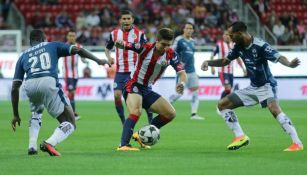 Isaac Brizuela intenta pasar entre dos jugadores rayados