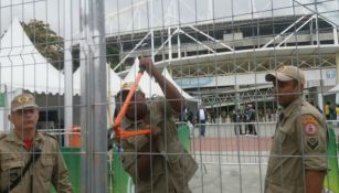 Los bomberos tratando de romper el candado de una puerta del estadio Olímpico