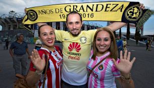 Aficionados posan con una bufanda del América