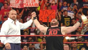 Kevin Owens festeja con Triple H el triunfo