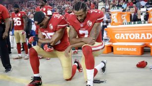 Colin Kaepernick y Eric Reid hincados durante el himno de EU