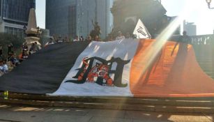 Aficionados de Tigres extienden una bandera en el Ángel de la Independencia