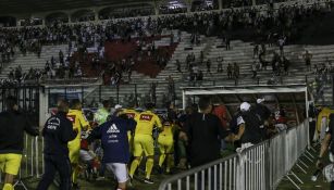 Los jugadores salen de la cancha escoltados por los policías