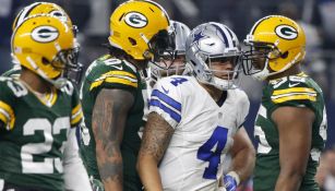 Dak Prescott pasa junto a los defensivos de Green Bay durante el juego de Comodín en 2017