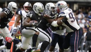 Lynch corre con el balón durante el juego frente a los Pats