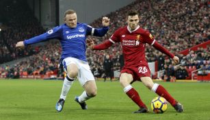 Wayne Rooney y Andrew Robertson luchan por el balón