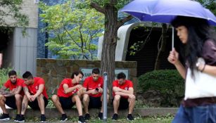 Futbolistas de Chile en una banqueta de la ciudad Sapporo, Japón