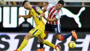 Guido Rodriguez y Alan Pulido disputan el balón en el Clásico Nacional