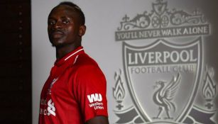 Sadio Mané posa junto al escudo del Liverpool