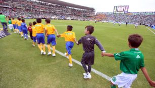 Niños saltan al terreno de juego durante el protocolo