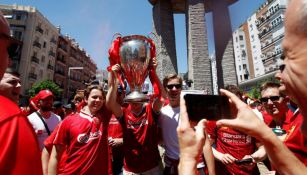 Aficionados del Liverpool posan con una Orejona