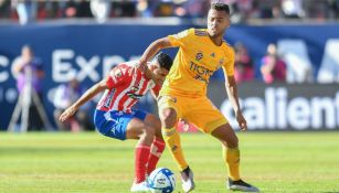 Jugadores del Atlético de San Luis y Tigres disputan un balón