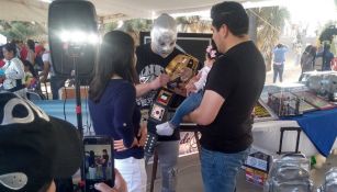 Imitador del Hijo del Santo firmando a fanáticos