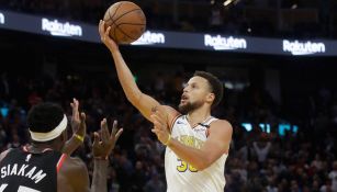 Stephen Curry intenta anotar ante Raptors 